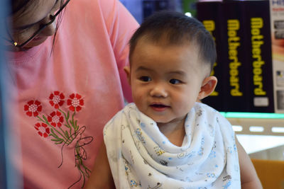 Midsection of mother with cute son sitting indoors