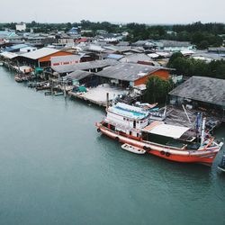 High angle view of nautical vessel moored on river by buildings in city