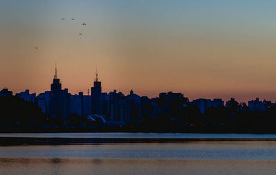 Silhouette of buildings against sky during sunset