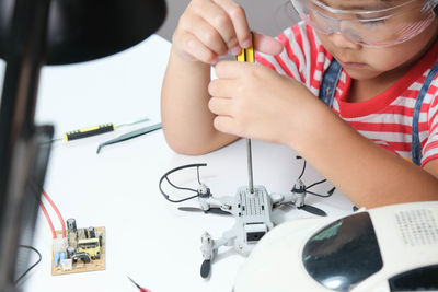 Girl fixing drone at home