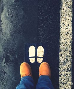 Low section of man standing on road