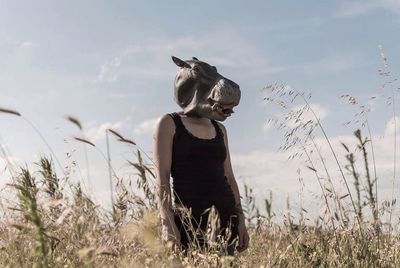 Woman standing on field against sky