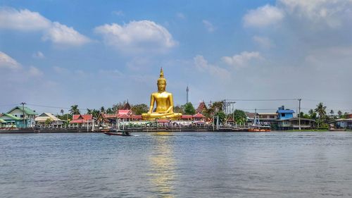 View of river by building against sky