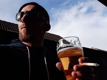 Low angle view of man drinking glass