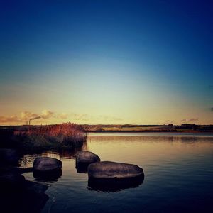 Scenic view of lake against clear blue sky