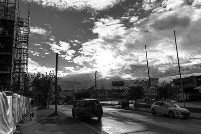 Cars on road in city against sky