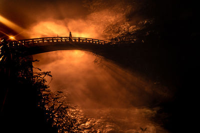 Low angle view of illuminated bridge against sky at sunset