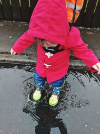 Low angle view of girl standing in puddle