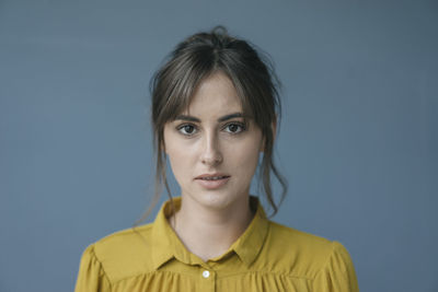 Portrait of a young woman wearing a yellow blouse