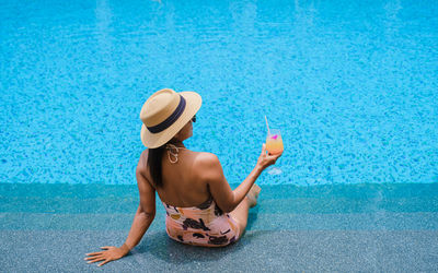 Rear view of woman swimming in pool