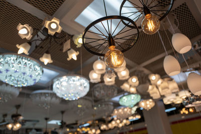 Low angle view of illuminated pendant lights hanging from ceiling at restaurant