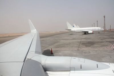 Airplane on airport runway against sky