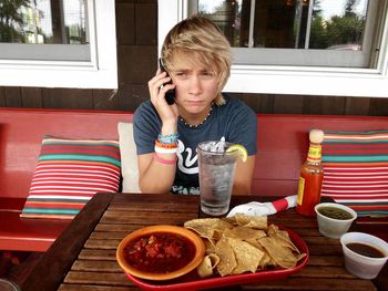 Portrait of boy eating food outdoor cafe