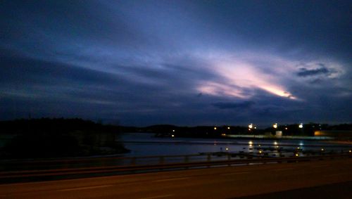 Illuminated river against sky at night