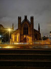 Illuminated building against sky at night