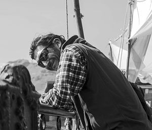 Low angle view of people on sailboat against sky