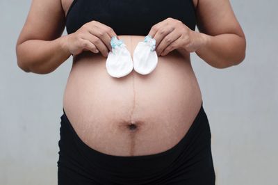 Midsection of woman with arms raised