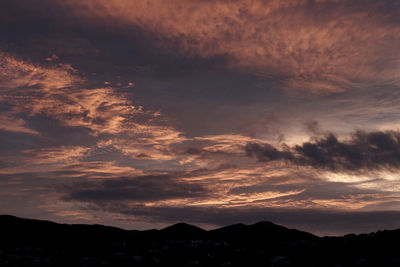 Scenic view of dramatic sky over silhouette mountains