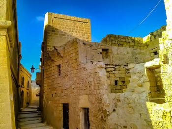 Low angle view of old building against blue sky