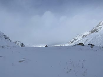 Scenic view of snow covered mountains against sky