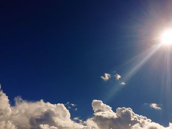 Low angle view of bright sun in sky