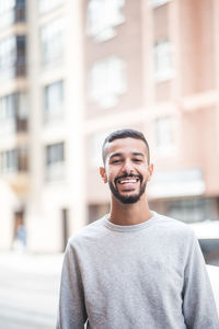 Portrait of smiling mid adult man standing in city