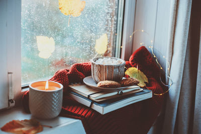 Breakfast with books and sweater on window sill at home