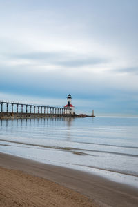 Pier on beach against sky