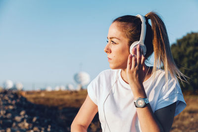 Portrait of young woman looking away outdoors