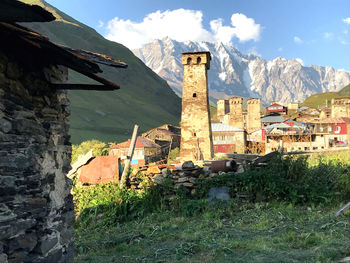 Abandoned building by mountains against sky