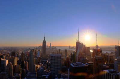 Illuminated cityscape against sky during sunset