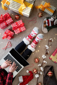 Directly above shot of young woman using laptop by christmas decoration