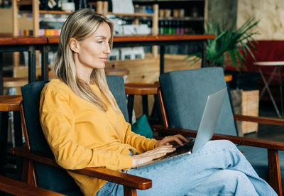 Focused woman browsing laptop in modern cafe