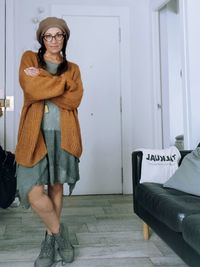 Portrait of young woman standing against wall