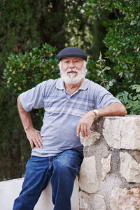 Portrait of a stylish older man wearing a beret on a green background