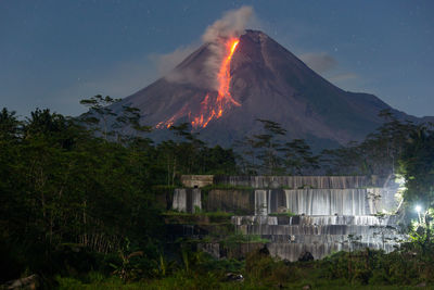 Scenic view of erupting volcano against night sky