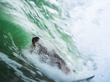 Blurred motion of man swimming in sea