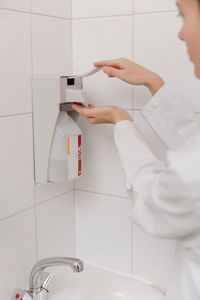 Midsection of scientist examining patient in bathroom