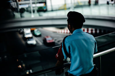 Rear view of man standing on railing