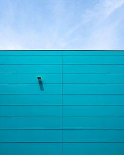 Closed blue wall against sky