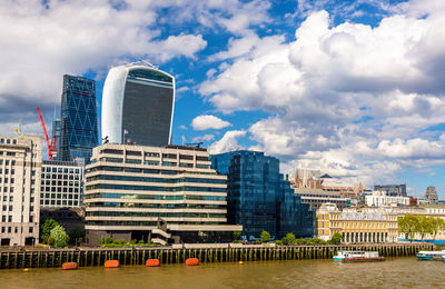 Buildings in city against cloudy sky