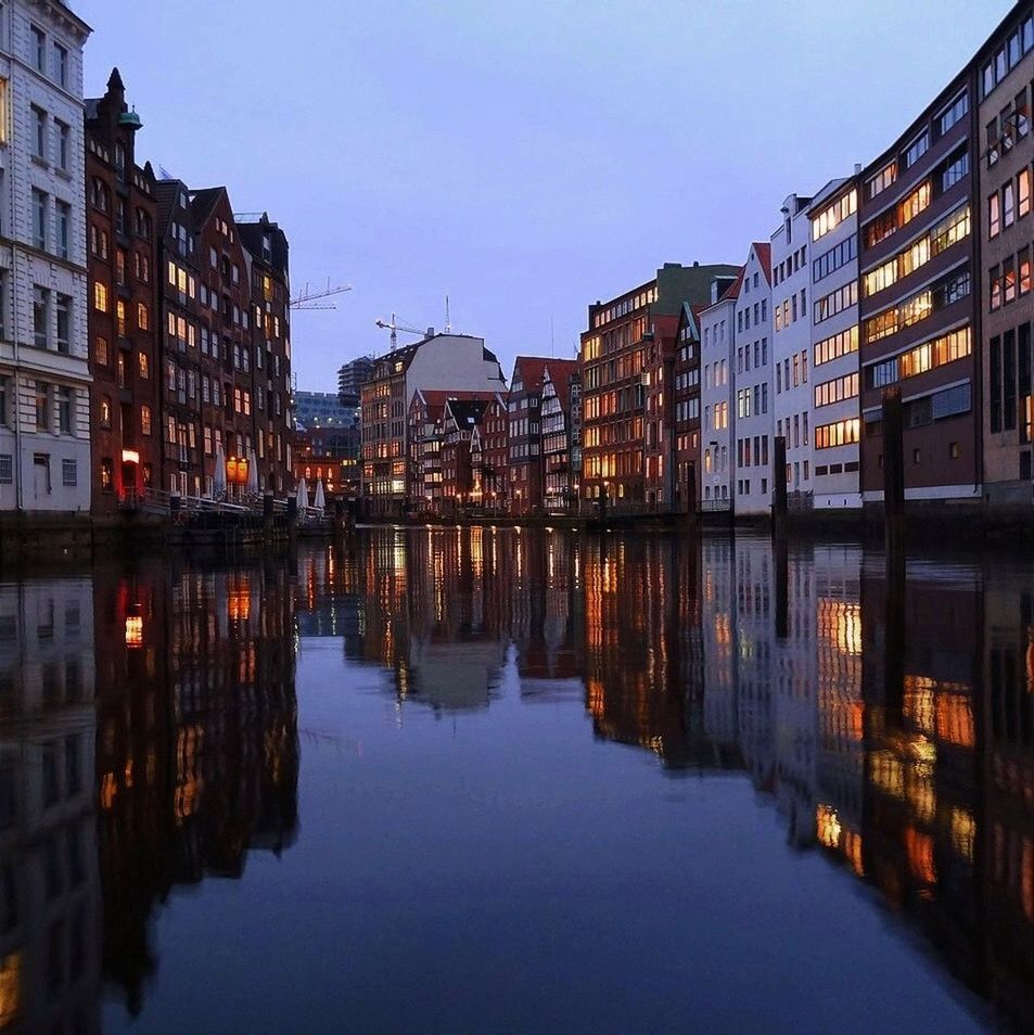 building exterior, architecture, built structure, reflection, water, waterfront, city, building, river, canal, clear sky, residential structure, residential building, sky, sunset, outdoors, residential district, illuminated, city life, cityscape