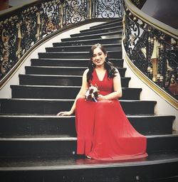 Portrait of smiling young woman on staircase