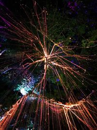 Low angle view of fireworks against sky at night