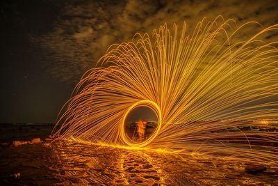 Low angle view of illuminated ferris wheel against sky at night