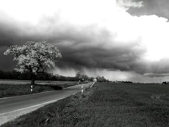 Country road against cloudy sky