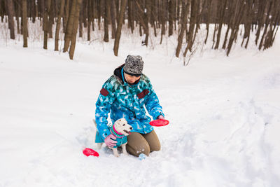 Low angle view of girl playing on snow covered field