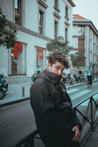 Man on street against buildings in city