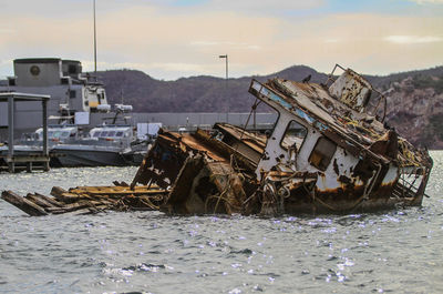 Abandoned boat on shore against sky