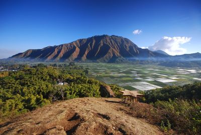 Scenic view of volcanic mountain against blue sky